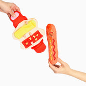 Jouet de fouille Le Hot Dog et son pain tenus à deux mains sur fond blanc