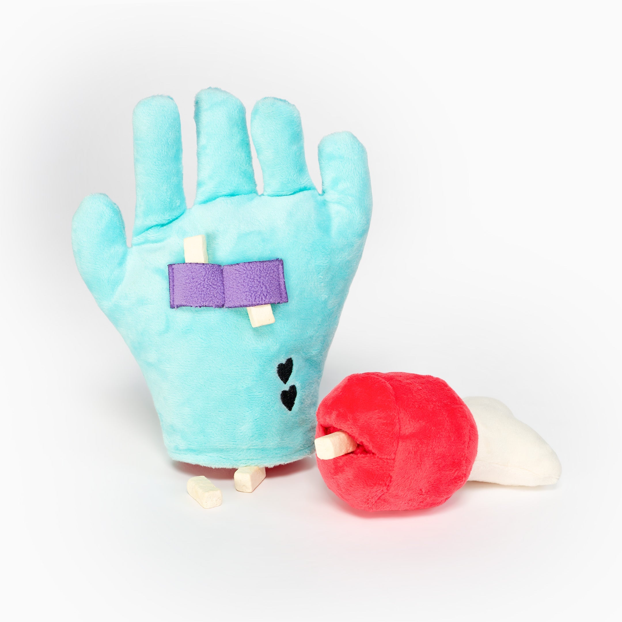 Paume de la main en peluche avec friandises sous les sangles violettes, à côté de l'os amovible