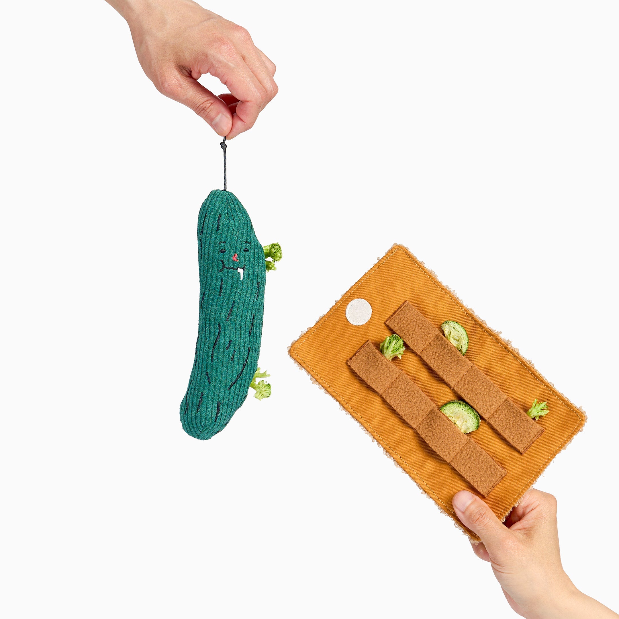 Cornichon en peluche et son enveloppe de fouille tenus à la main