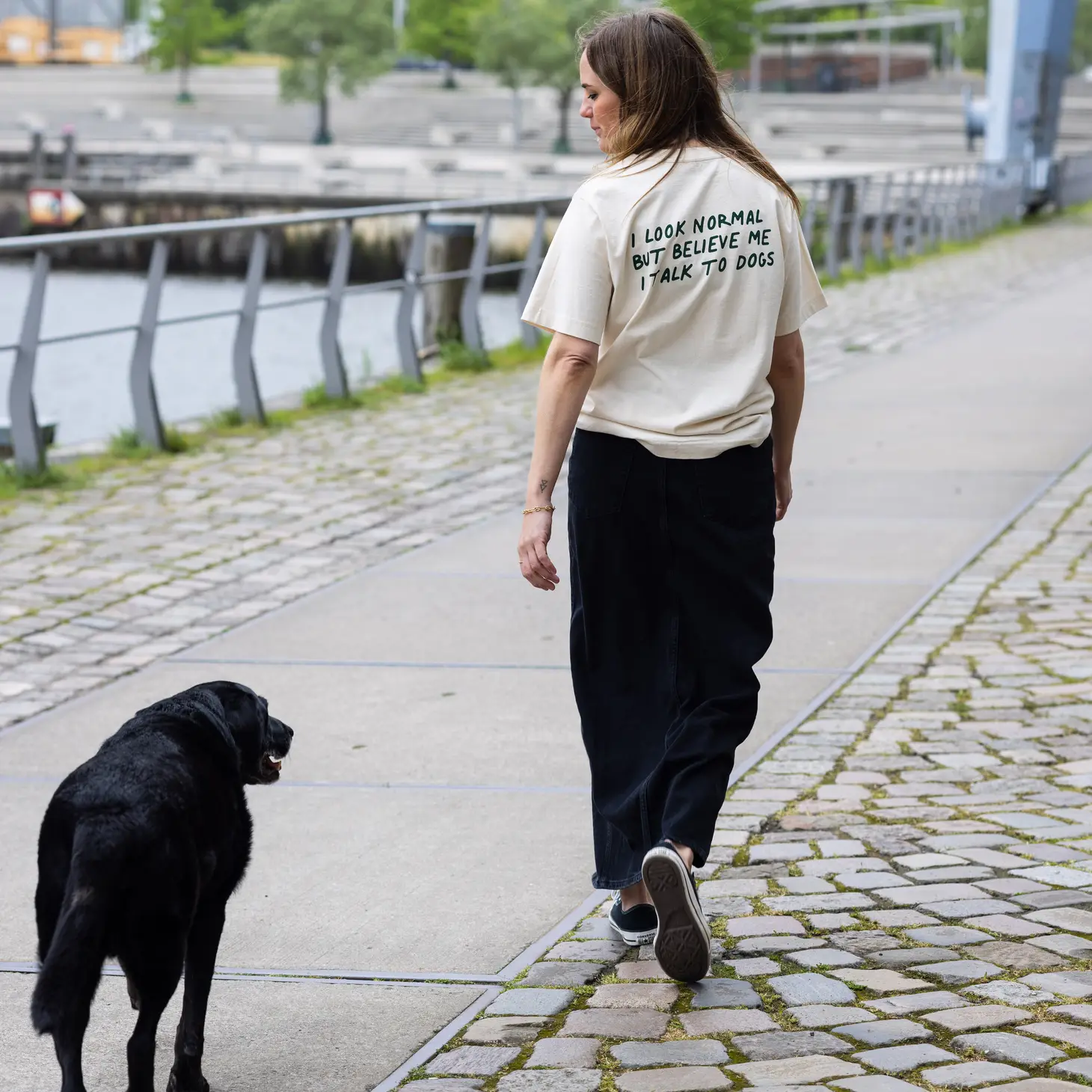 Personne portant un T-shirt "J'ai l'air normal mais croyez-moi, je parle aux chiens" - Beige